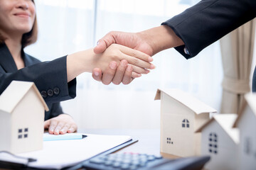 Fototapeta na wymiar Sealing a deal concept, Estate agent shaking hands with his customer after contract signature.