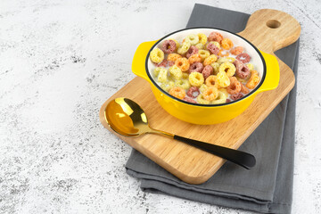 Ring cereals and milk in bowl on table