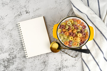 Ring cereals and milk in bowl on table. Cereals and book.