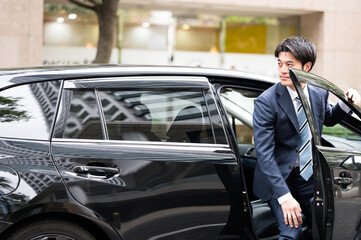 Fototapeta na wymiar 車から降りる男性　ビジネスマン　スーツ