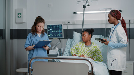 Multi ethnic specialists consulting patient with illness to give prescription treatment and...