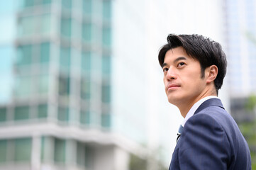 ビジネス街で遠くを見つめるビジネスマン