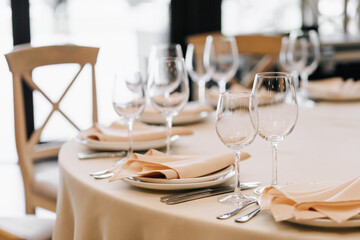 Wine glasses in the foreground. Wedding Banquet or gala dinner. The chairs and table for guests, served with cutlery and crockery.