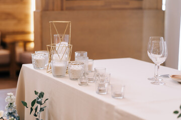 Decorative candles for a wedding stand on the table in beige shades