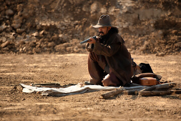 western cowboy portrait Holding a gun in a dry area