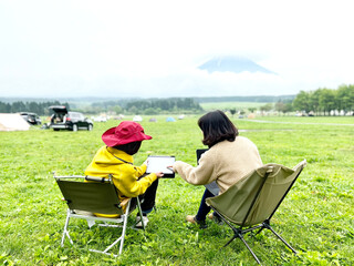 キャンプ場でリモートワークする2人の女性