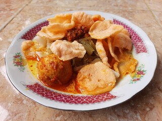 Lontong sayur or vegetable curry with rice pressed cake is an Indonesian traditional rice dish, served with plate