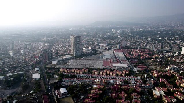 drone view of a shopping center and a neighborhood in mexico city during a very polluted day