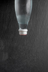 glass bottle of mineral water, photo from above on a dark background with space for text