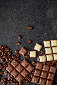 white and dark chocolate with coffee beans, top view photo on a dark background with space for text
