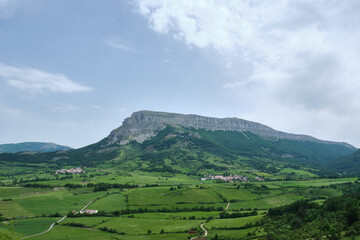 Obraz premium panoramic view of uanu and torrano small town in the ergoyena valley at the foot of the sierra de san donato surrounded by large meadows. rural tourism. Navarre, Spain