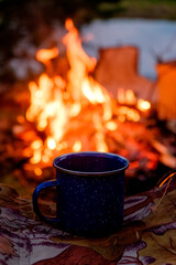 Camping mug and bonfire in the evening