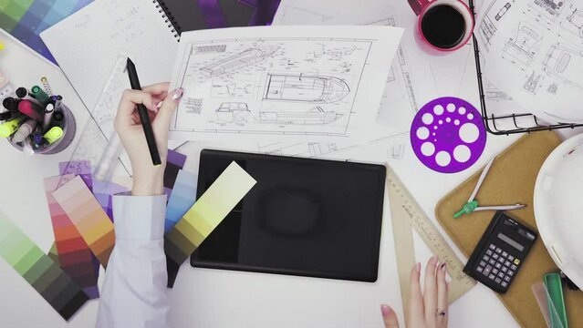 Top view of a creative designer using a graphic tablet while working at his desk