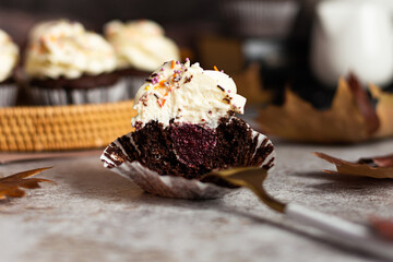 Chocolate cupcakes in a wicker basket. One cupcake cut with a fork