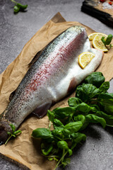 Raw trout fish without a head on parchment. Close-up
