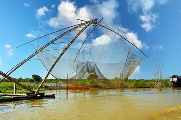 Traditional bamboo raft with basic fishing net on wooden candilever at shrimp farm on tonle sap...