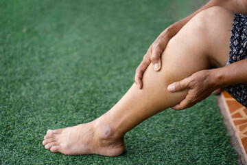 Closeup elderly hands massage her calf because of cramping. Concept : health problems. Senior...