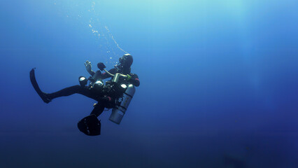 Underwater photographer going into the deep sea. 