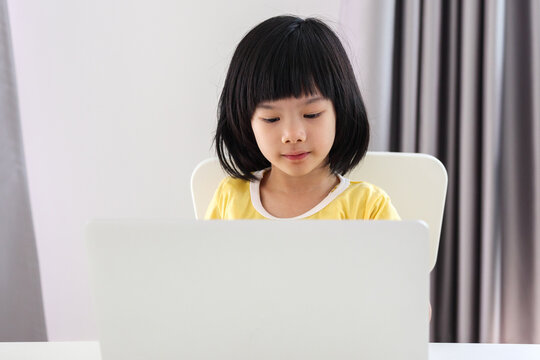 little asian girl student study online using laptop computer at home
