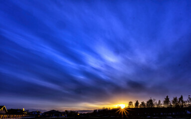 Evening blue sky with sun and rays