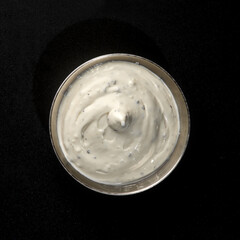 garlic sauce in a metal gravy boat on a black background for fast food