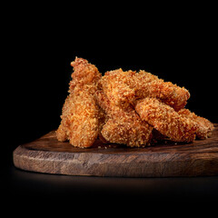 set deep-fried chicken legs set, chicken nuggets on a wooden tray, isolated on black.