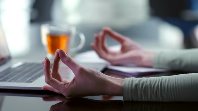Cropped shot of woman meditating at workplace