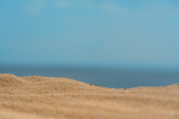 Fototapeta na wymiar Closeup view of sandy beach near sea on sunny day