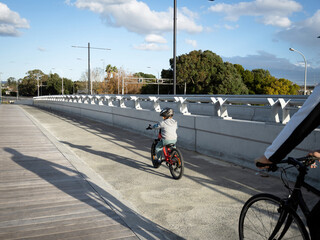 View of child riding bike followed by parent