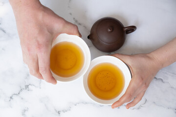 Cup of tea in female and male hands. Tea ceremony concept