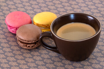 cup of coffee with macaroons on a table