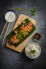 Homemade Grilled chicken fillets on a wood board on the table. Horizontal top view from above