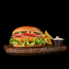 Delicious fastfood fresh tasty burger. crispy, breaded chicken burger with and vegetable on wooden cutting board