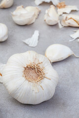 garlic bulb and cloves on rustic and mottled gray surface