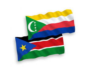 National vector fabric wave flags of Union of the Comoros and Republic of South Sudan isolated on white background. 1 to 2 proportion.