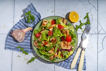 Healthy balanced diet food. Green salad with grill chicken breast fillet, tomatoes, olive oil top view copy space