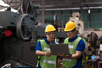 Portrait of Asian engineer worker discussing about manufacturing machinery while using laptop in the factory. Group of engineer male worker working in the manufacturing factory.