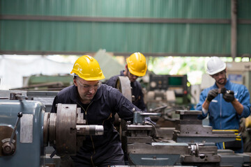 Group of engineer male worker maintaining machine lathe metal at the industry factory. Group of Factory worker check or maintenance CNC machine in industry factory