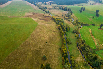 Aerial view of the green fields and small river. 