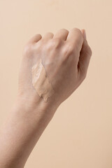 Foundation cream smear test on female hand, CC cream stroke, tinted moisturiser applied on woman...
