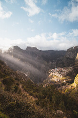 Fototapeta premium Very well-known tourist destination, Curral das freiras, a village nestled in the mountains with minimal sunlight. Aerial view of valley of nuns at sunset and peak of mountains in fog
