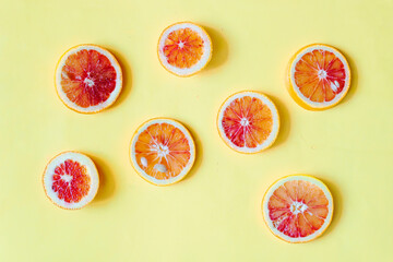 Blood Sicilian fresh oranges on wooden cutting board. Sliced ripe juicy citrus fruits on yellow...