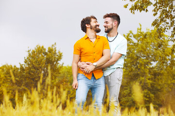 Gay couple in the park. Young man hugging his boyfriend. High quality photo