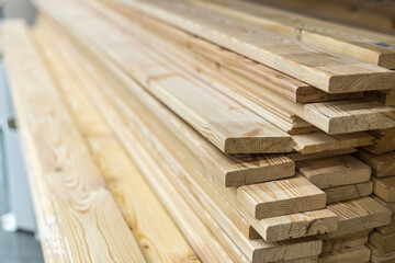 Flat wooden boards in a stack. Building materials. Beams for carpentry, manufacture and repair of furniture. Selective focus.