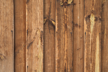 The texture of a wooden old vintage fence made of planks. Natural color of faded wood with old nails