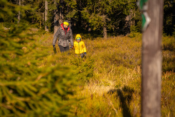 Mum and child are walking along the mountain hiking trail. Family spending time.