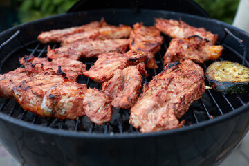 Pork neck getting grilled outdoors