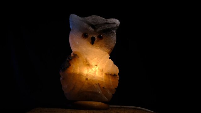 night light lamp lantern salt owl with warm yellow light inside on black background slide movie