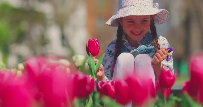 Tulips and happy beautiful gir in flowers garden