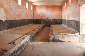 Intérieur d'une cellule collective du bagne de Saint-Laurent-du-Maroni en Guyane Française lors d'une journée ensoleillée.